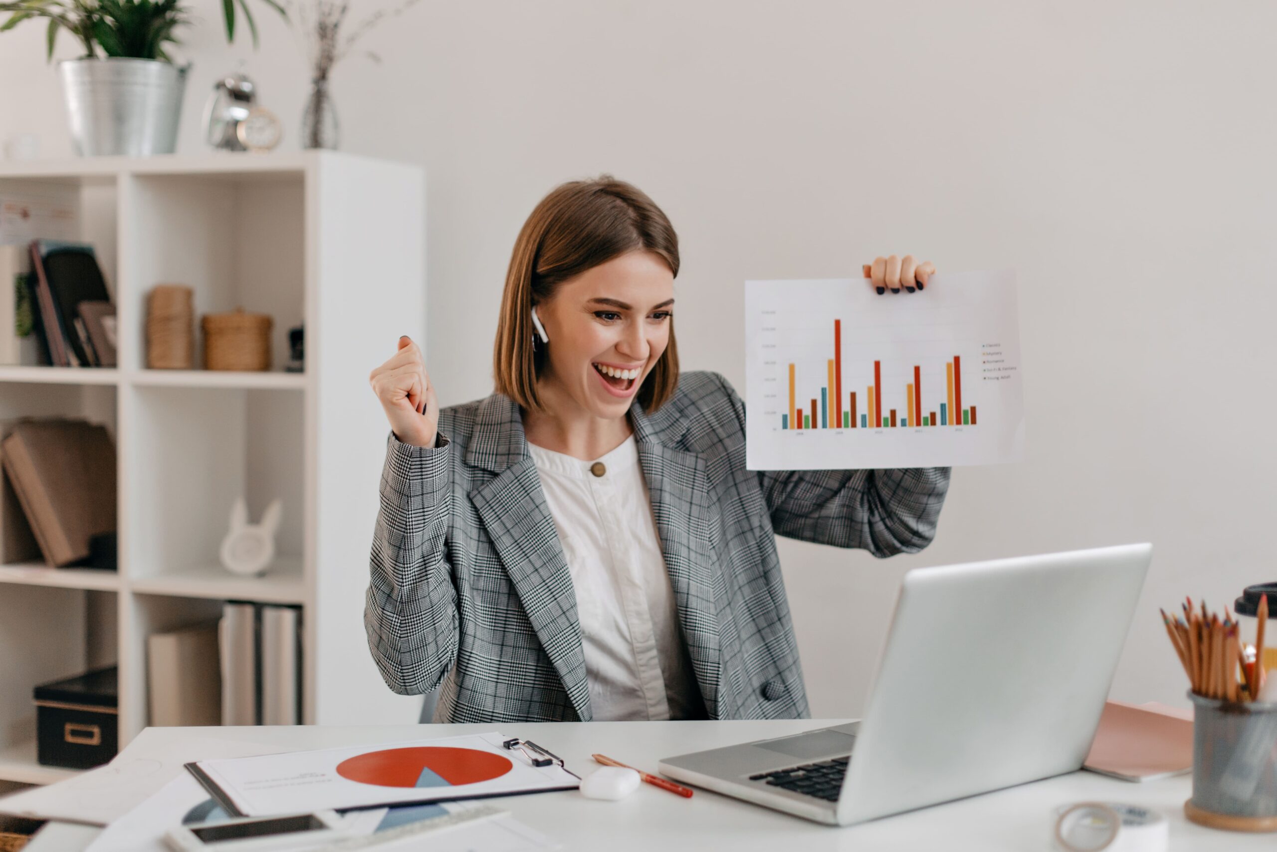 close-up-portrait-happy-business-woman-stylish-outfit-girl-high-spirits-demonstrates-chart-via-skype-scaled